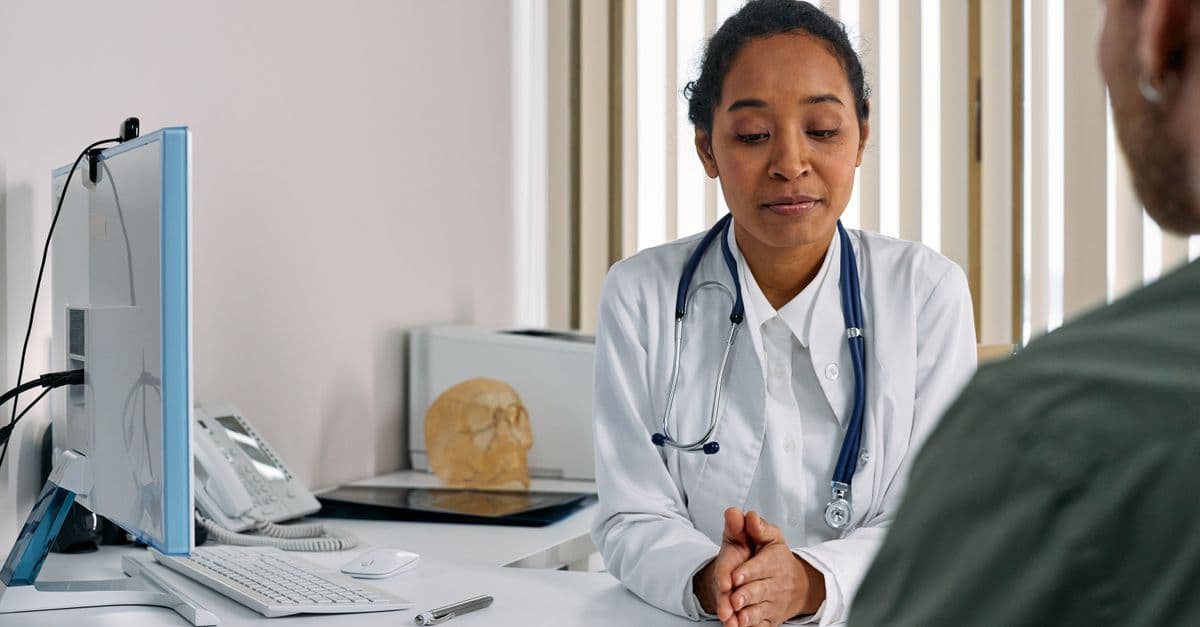 A female doctor consulting a patient in a modern medical office setting.