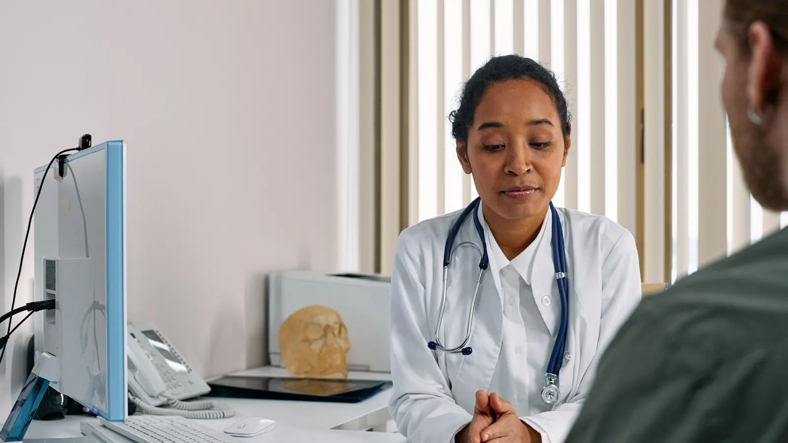 A physician talking with a male patient in a consulting room